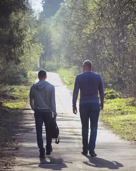 Two people walking side by side, reflecting the philosophy of walking beside someone at Keystone Lodge.