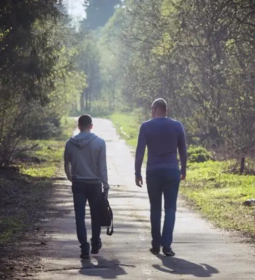 Two people walking side by side, reflecting the philosophy of walking beside someone at Keystone Lodge.
