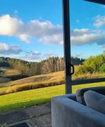 Grassy hills and trees seen through the large window of the therapy room at Keystone Lodge