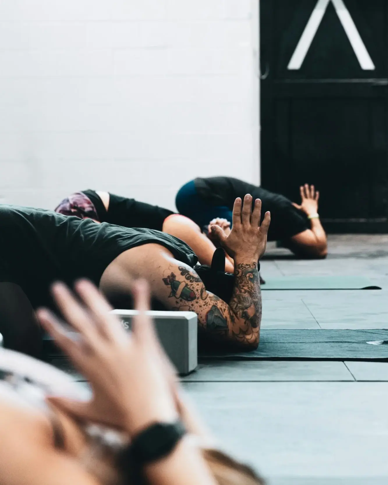 People lying on mats in a calm studio during a breathwork session.
