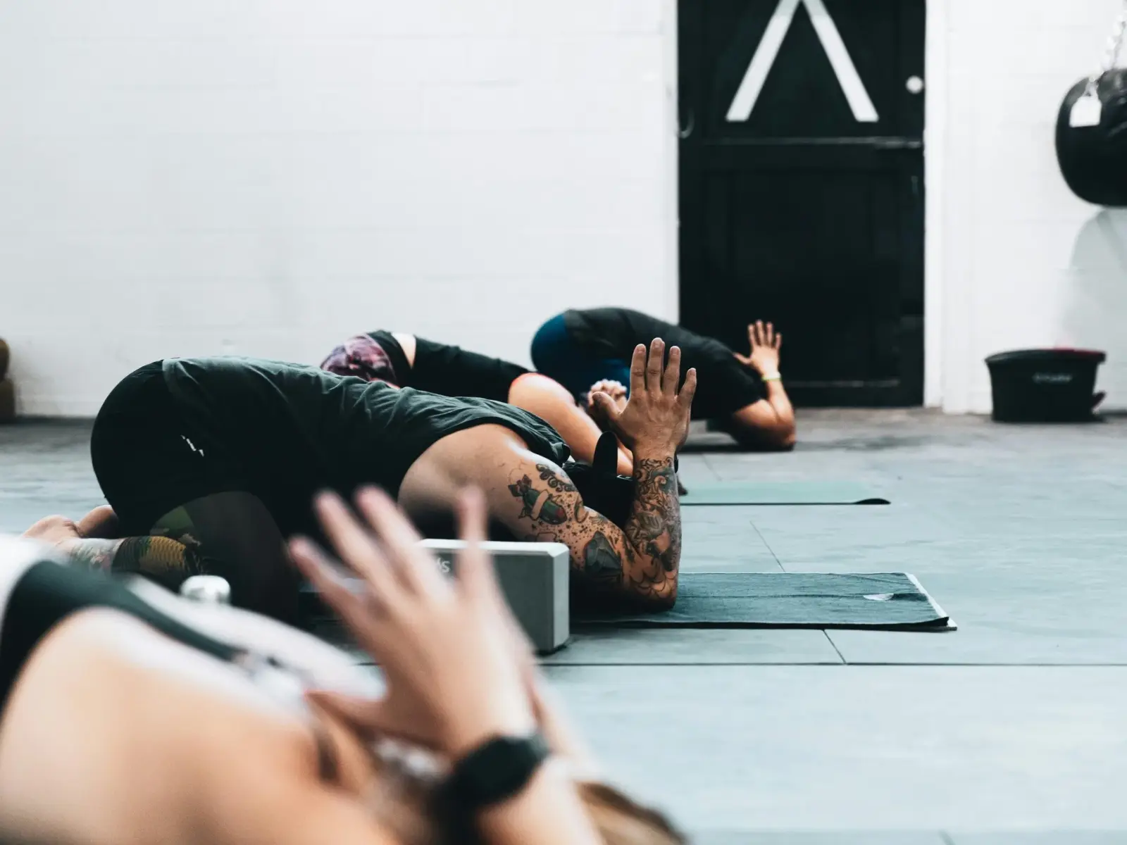 People lying on mats in a calm studio during a breathwork session.